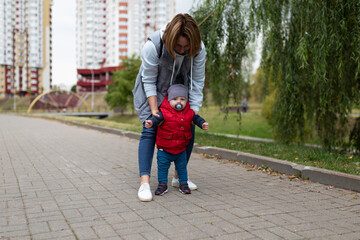 first steps of a baby by mom during a street walk © Ivan Traimak