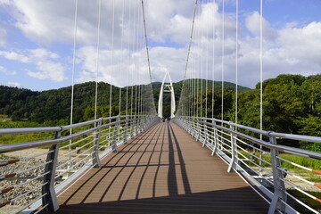 Scenic footbridge with cloudy weather Green Mountains and Blue sky at Waterlands, South Korea