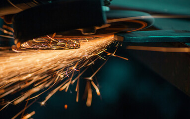 flying sparks from grinding metal, work with a manual grinder, closeup shot - obrazy, fototapety, plakaty