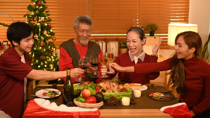Image of happy family celebrating Christmas together at home lighted with soft lights and candles. Celebration, holidays and people concept