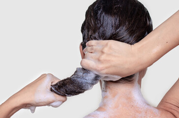 back view woman hold wet hair with shampoo foam in ponytail with both hands isolated on white beige...