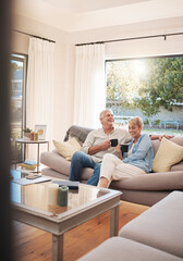 Fototapeta na wymiar Senior couple with coffee or tea and relax on sofa in their living room happy with retirement, real estate and lifestyle. Elderly people drink on couch or in lounge together while talking of marriage