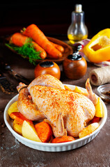 Raw chicken marinated in sour cream sauce with vegetables is in a white tray.