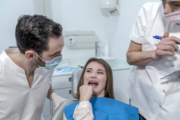 Obraz na płótnie Canvas Teen female with toothache pain sitting to dental chair.