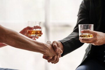 Sad depressed addicted drunk guy, Alone asian man drinker alcoholic sitting at bar counter with glass drinking whiskey. shaking hands.