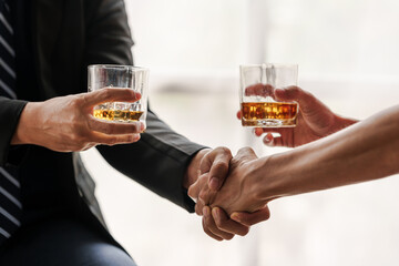 Sad depressed addicted drunk guy, Alone asian man drinker alcoholic sitting at bar counter with glass drinking whiskey. shaking hands.