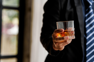 Sad depressed addicted drunk guy, Alone asian man drinker alcoholic sitting at bar counter with glass drinking whiskey.