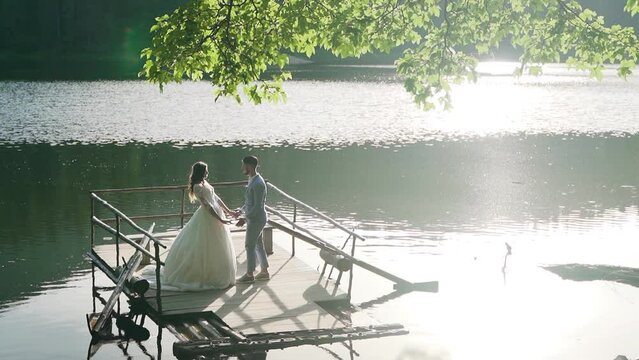 Young couple are sailing on a boat in Synevyr Lake in Ukraine. Aerial view 4K.