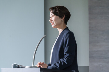 プレゼンをするスーツを着たショートヘアーの日本人女性