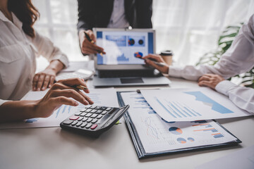 Young colleagues discuss business brainstorming and price charts analyze business people at the desk brilliantly in modern collaborative office teamwork ideas. Calculate personal tax for customers