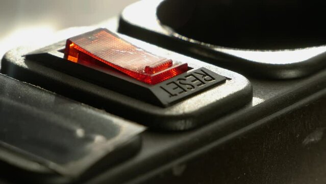 human figer press and off red lighting outlet switch on black Electric Extension Cord, closeup