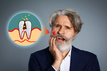 Mature man suffering from toothache on grey background