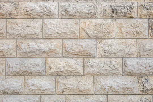 abstract background of beige stone lined old wall close up