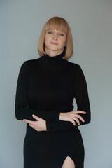 Beautiful blonde businesswoman portrait in black dress on background