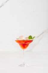 Alcoholic drink with tomato juice in a glass with ice close-up on a white background