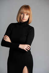 Beautiful blonde businesswoman portrait in black dress on background