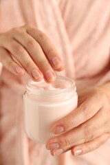 Obraz na płótnie Canvas Woman holding jar of hand cream, closeup