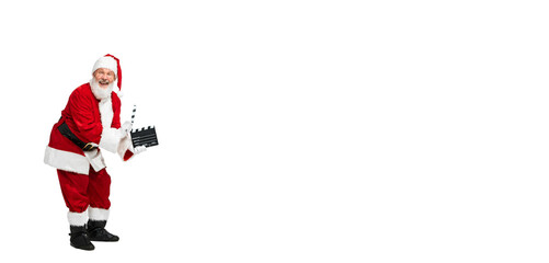 Portrait of senior man in image of Santa Claus posing with Clapperboard isolated over white background. Flyer