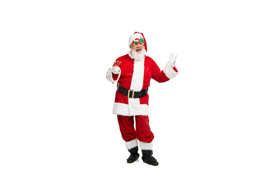 Portrait of happy senior man in image of Santa Claus in festive glasses posing isolated over white background