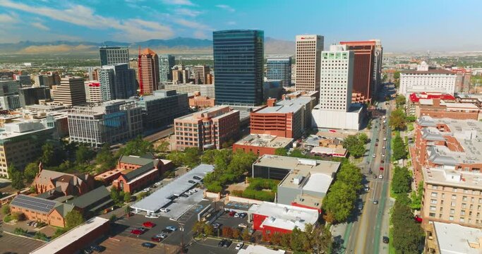 Bright architecture in financial downtown of sunny Salt Lake City in Utah. Beautiful American city at backdrop of mountains.