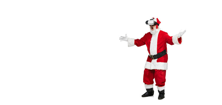 Portrait of senior man in image of Santa Claus posing in VR glasses isolated over white background