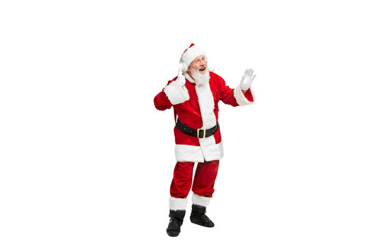 Portrait of senior man in image of Santa Claus listening to music in headphones isolated over white background