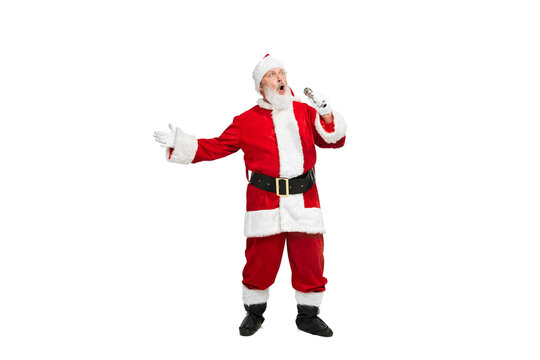 Portrait of senior man in image of Santa Claus singing in microphone isolated over white background
