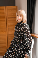 Portrait of blonde woman 35 years old in dress indoor