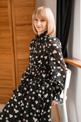 Portrait of blonde woman 35 years old in dress indoor