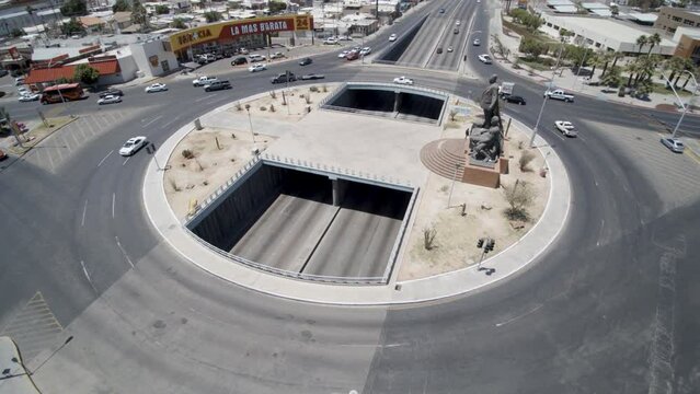 View of a drone flying forward over a street roundabout-bridge