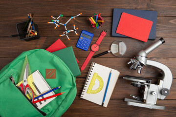 Back to school - books and school backpack on the desk in the auditorium, Education concept.