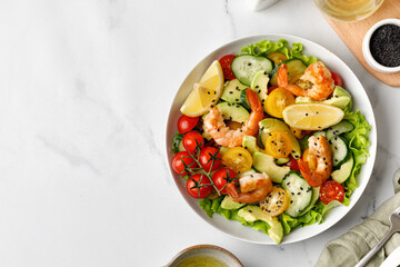 Fresh salad with shrimps, prawns, avocado and tomatoes. Shrimps salad with cucumber, avocado, green lettuce. Healthy diet seafood concept.