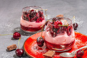 Delicious Italian dessert panna cotta with sweet cherry sauce, fresh berries and chocolate