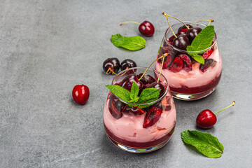 Delicious Italian dessert panna cotta with sweet cherry sauce, fresh berries and mint leaves