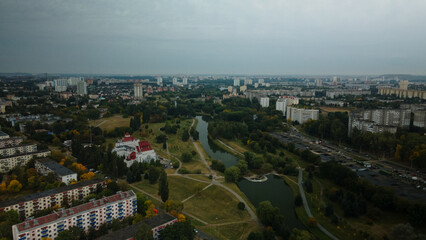 Fototapeta na wymiar River in the city park. Multi-storey buildings with infrastructure. Densely populated urban area. Overcast weather. Aerial photography.