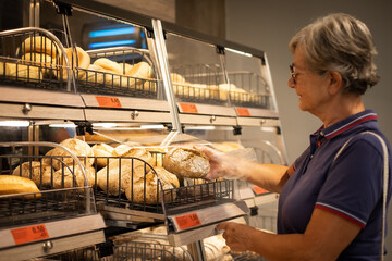 Senior woman choosing a cereal bread at the supermarket