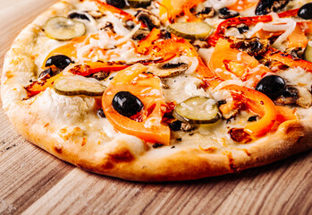 vegetarian pizza with Mozzarella cheese, grilled zucchini, mushrooms, red onion, pepper and olive. Italian pizza on wooden table background