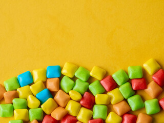Multicolored marmalade sweets on a yellow background. Place for text
