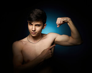 a healthy athletic teenager shows off his body against a dark background, the concept of proper nutrition