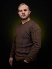 vertical portrait  blond man on a dark background, in a jacket
