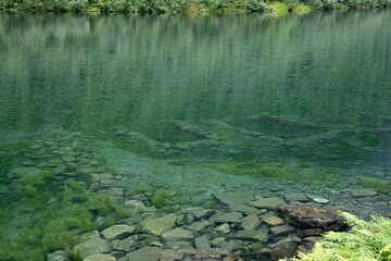 Wonderful landscapes in Norway. Vestland. Beautiful scenery of Lygnstoylvatnet lake. Remains of the flooded house foundations through the surface of the water are visible. Cloudy day. Selective focus