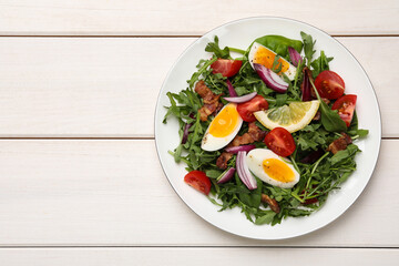 Delicious salad with boiled eggs, vegetables and bacon on white wooden table, top view. Space for text