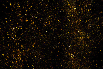 Golden glitter shiny dust particles glowing lights bokeh abstract background