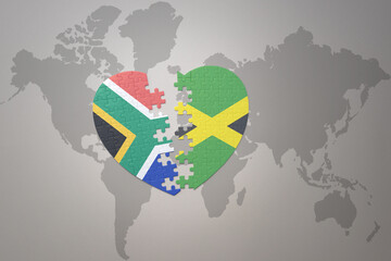 puzzle heart with the national flag of south africa and jamaica on a world map background. 3D illustration