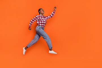Full body photo of energetic sportive lady hurry rush fast look empty space isolated on orange color background
