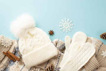 Winter concept. Top view photo of white mittens bobble hat knitted sweater snowflakes pine cones anise and cinnamon sticks on isolated pastel blue background - obrazy, fototapety, plakaty