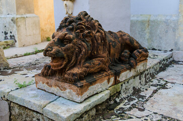 La statua di un leone di pietra su una tomba del cimitero di Tricase, borgo del Salento in Puglia