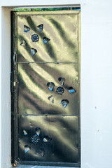 bespoke, original, creative metallic door set into a white wall of a building