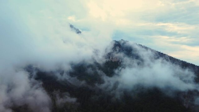 Flying through the thick fog in the mountain landscape after the rain.Aerial view. 