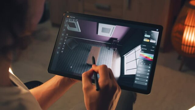 Male 3D designer using digital tablet computer and pencil and creating interior of house in professional design application while working on project remotely